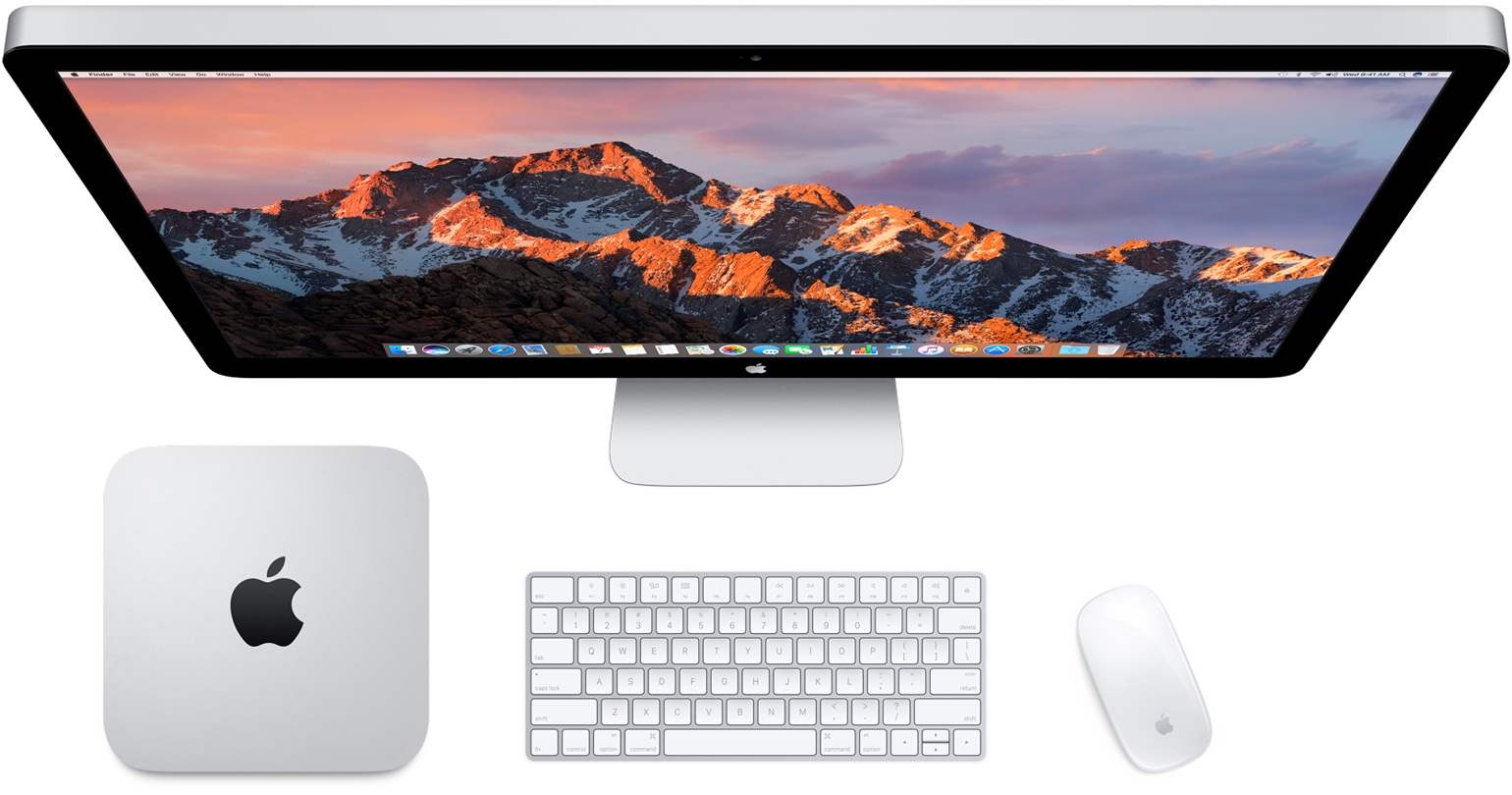 An image depicting an overhead view of an iMac along with a Mac mini, Apple wireless keyboard and mouse