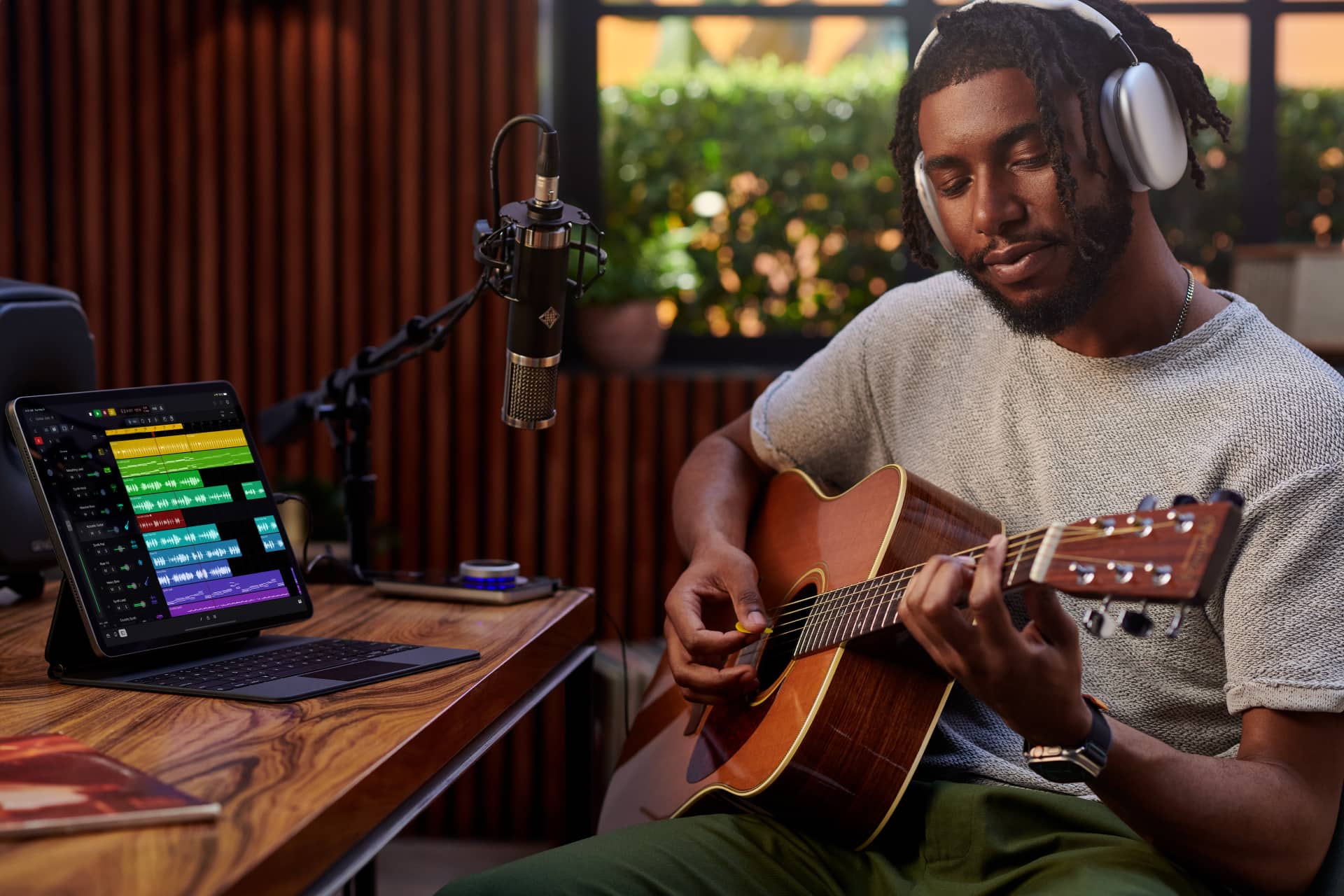 A person in their home studio recording a guitar session using Logic Pro for iPad