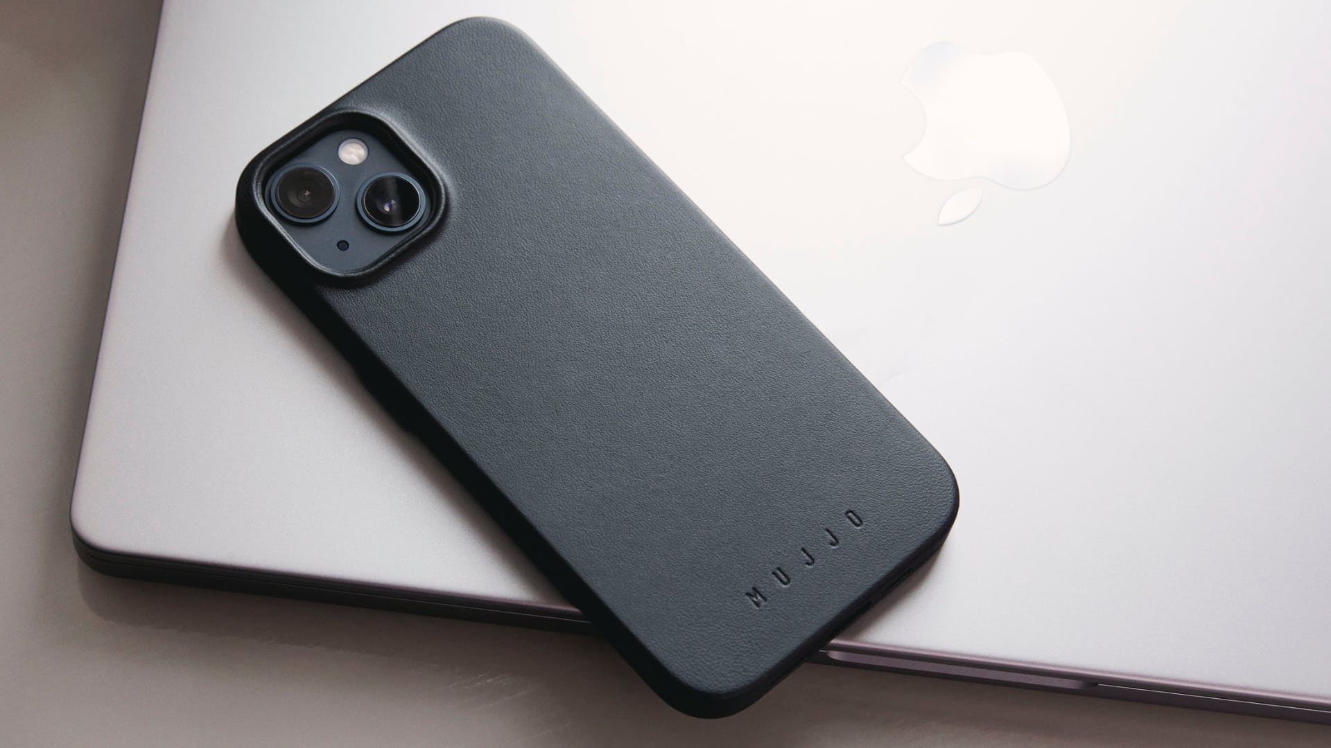 iPhone 15 in Mujjo's leather case facedown on MacBook