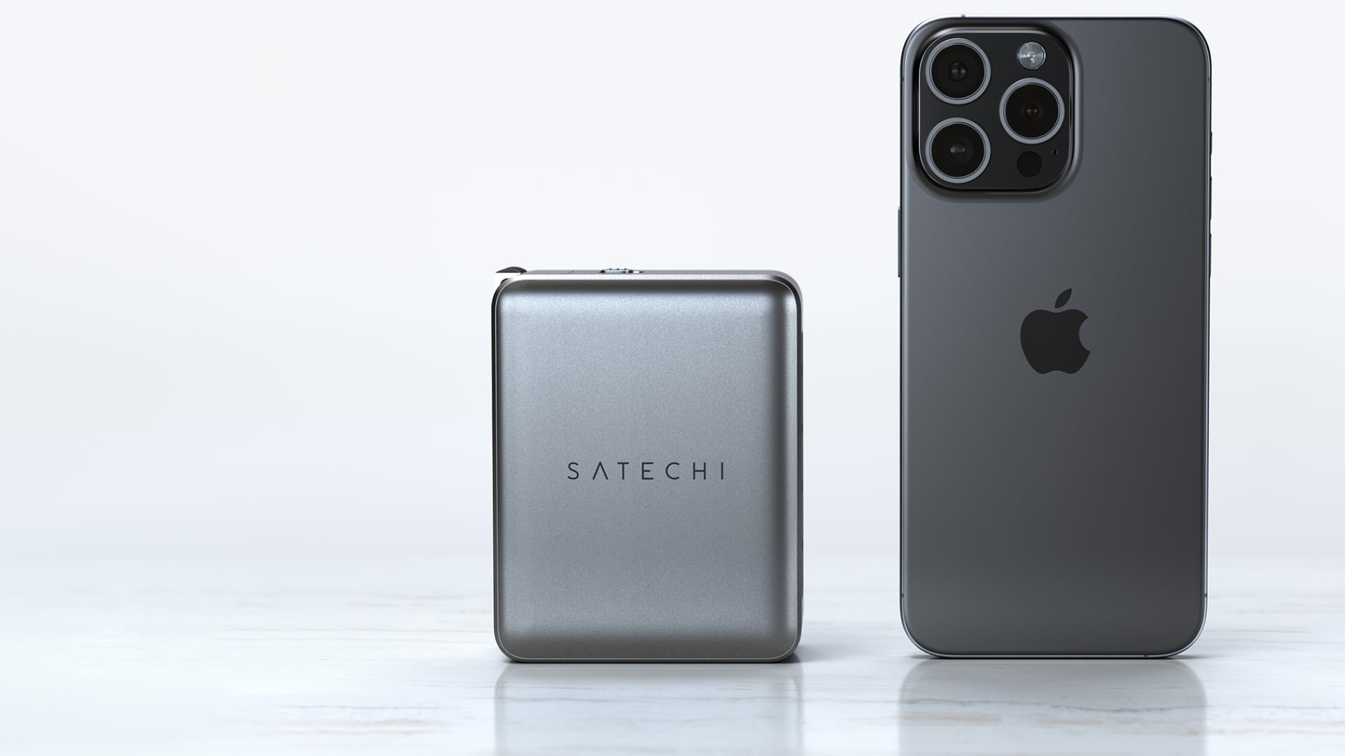 Satechi's 145W GaN charger next to iPhone 15 Pro