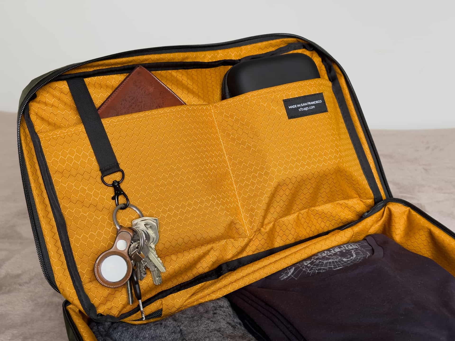 Wallet, keys and camera stabilizer in the pockets of Waterfield's X-Air Duffel travel bag
