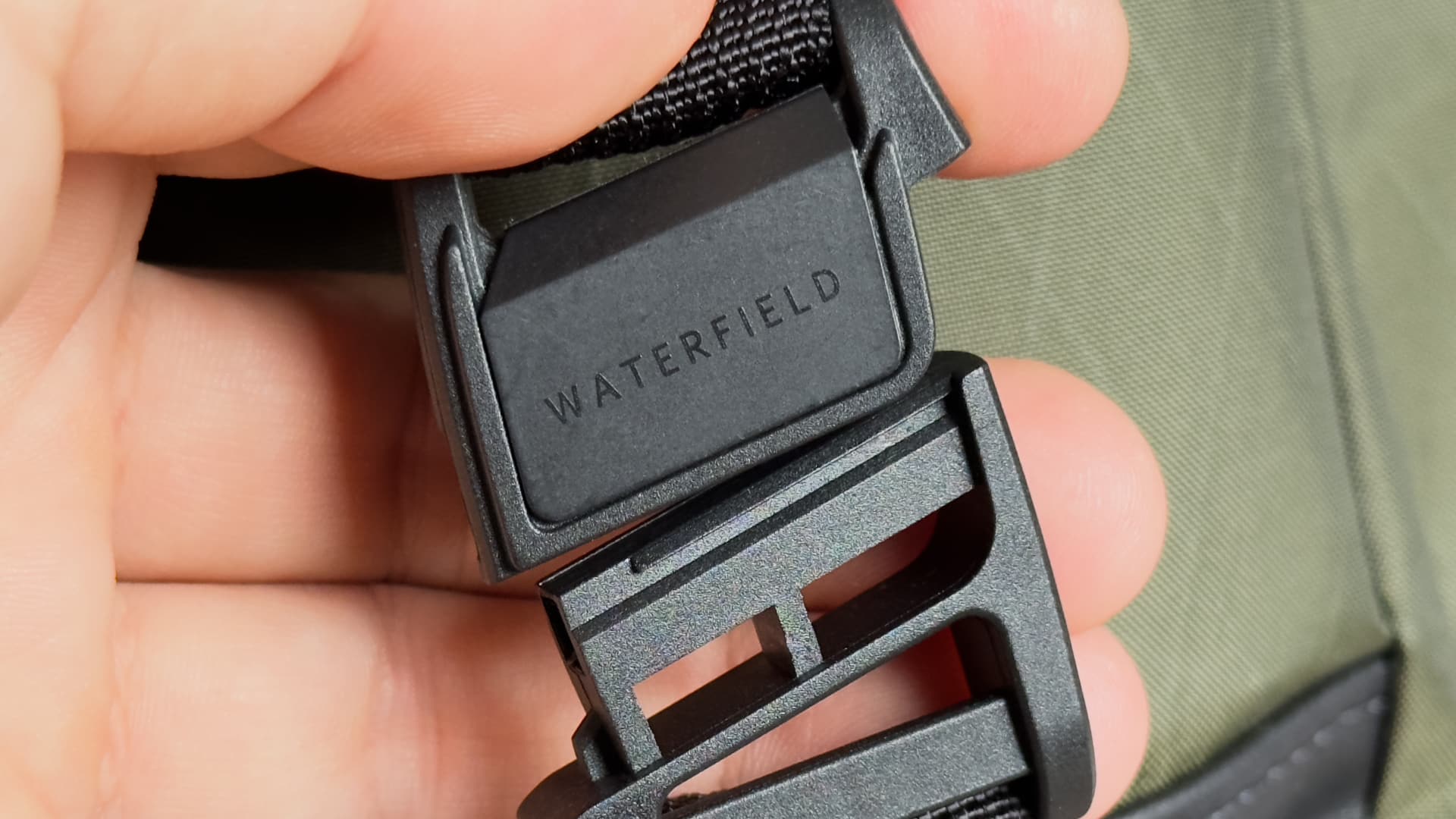 Closeup of the magnetic Fidlock buckle on Waterfield's X-Air Duffel travel bag
