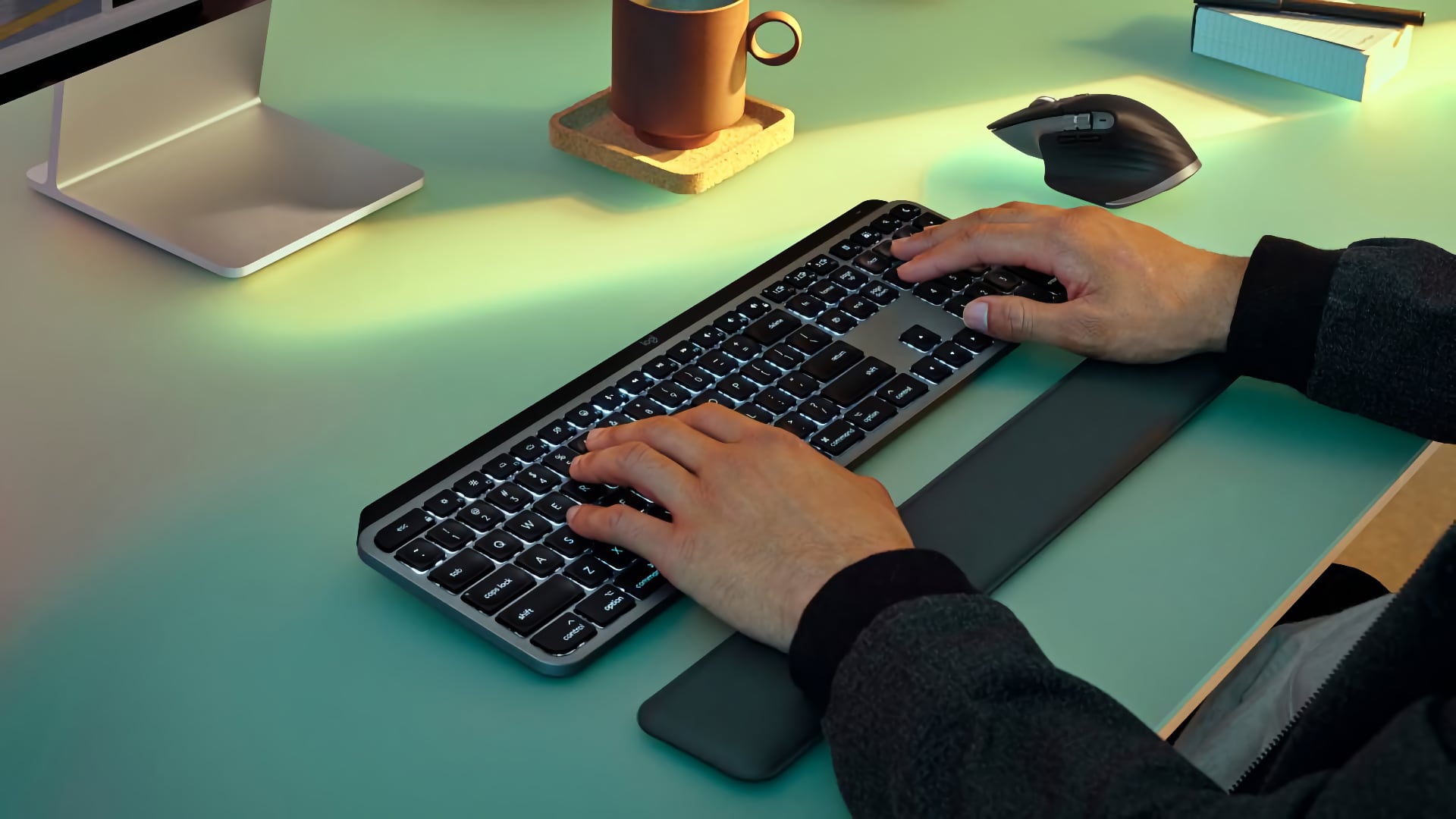 Male hands typing on Logitech's Mac keyboard with backlit keys