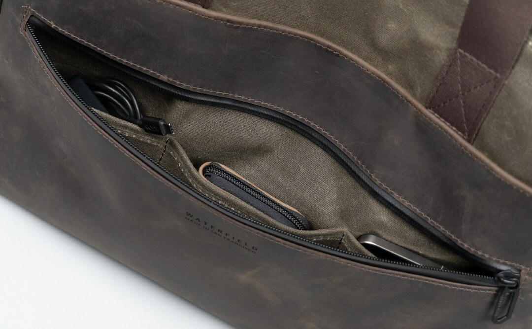 WaterField's leather cycling tote with the front panel open to showcase three internal pockets