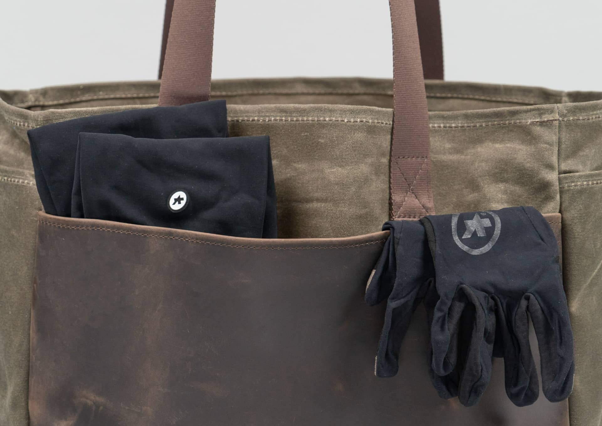 Back panel on WaterField's leather cycling tote with gloves half-inside