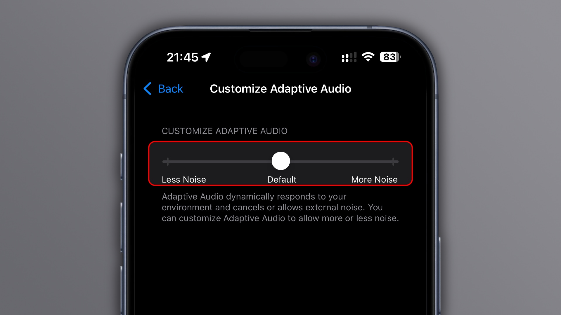 An iPhone showing the Customize Adaptive Audio screen in the Settings app with the slider to allow more or less external noise, set a against a light gray gradient background