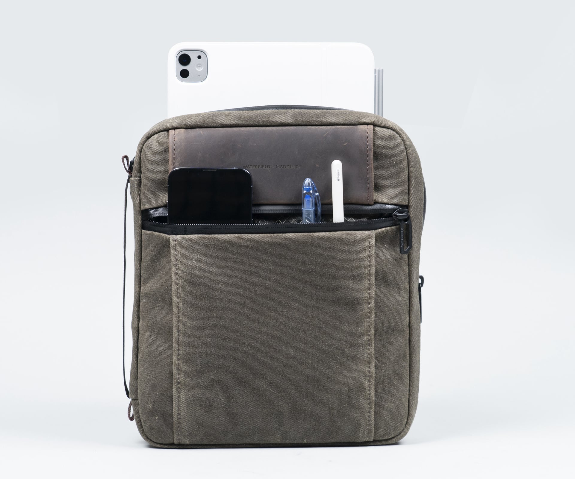 WaterField's tech folio closed, with an iPad and other smaller items sticking out.