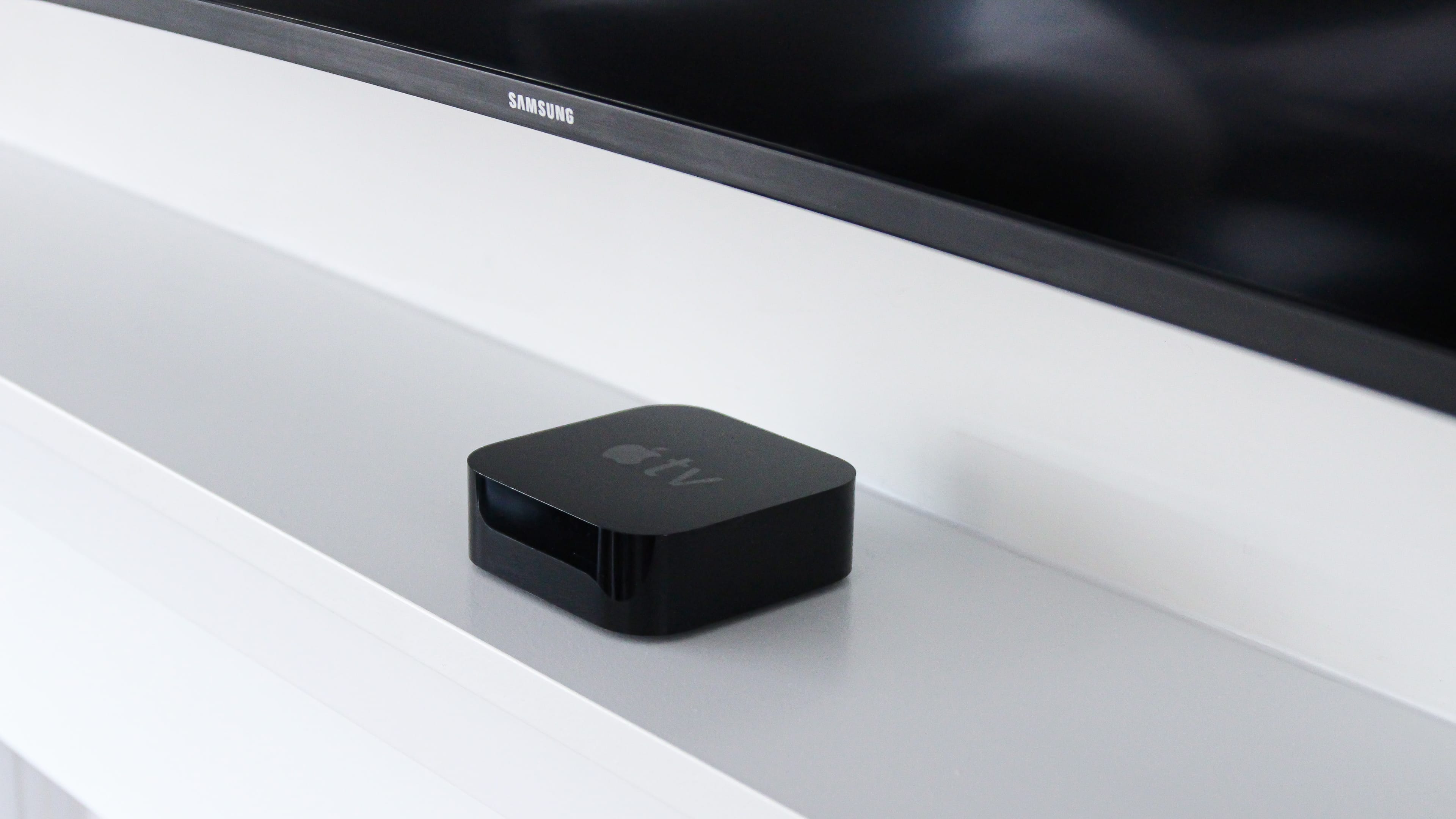 Apple TV sitting underneath a huge Samsung smart TV