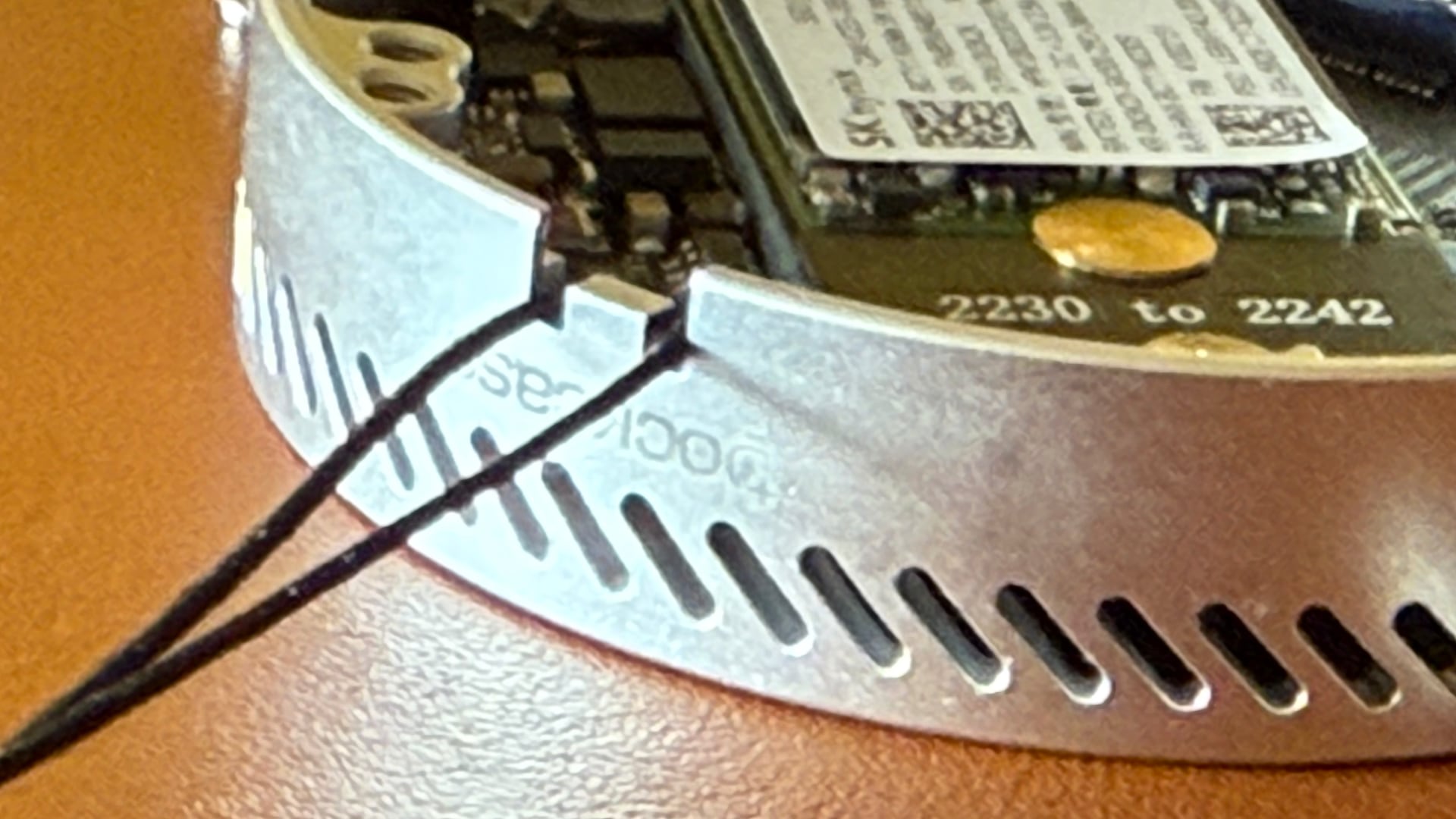 Closeup of a Dockcase MagSafe SSD enclosure with a backplate removed and a lanyard installed.