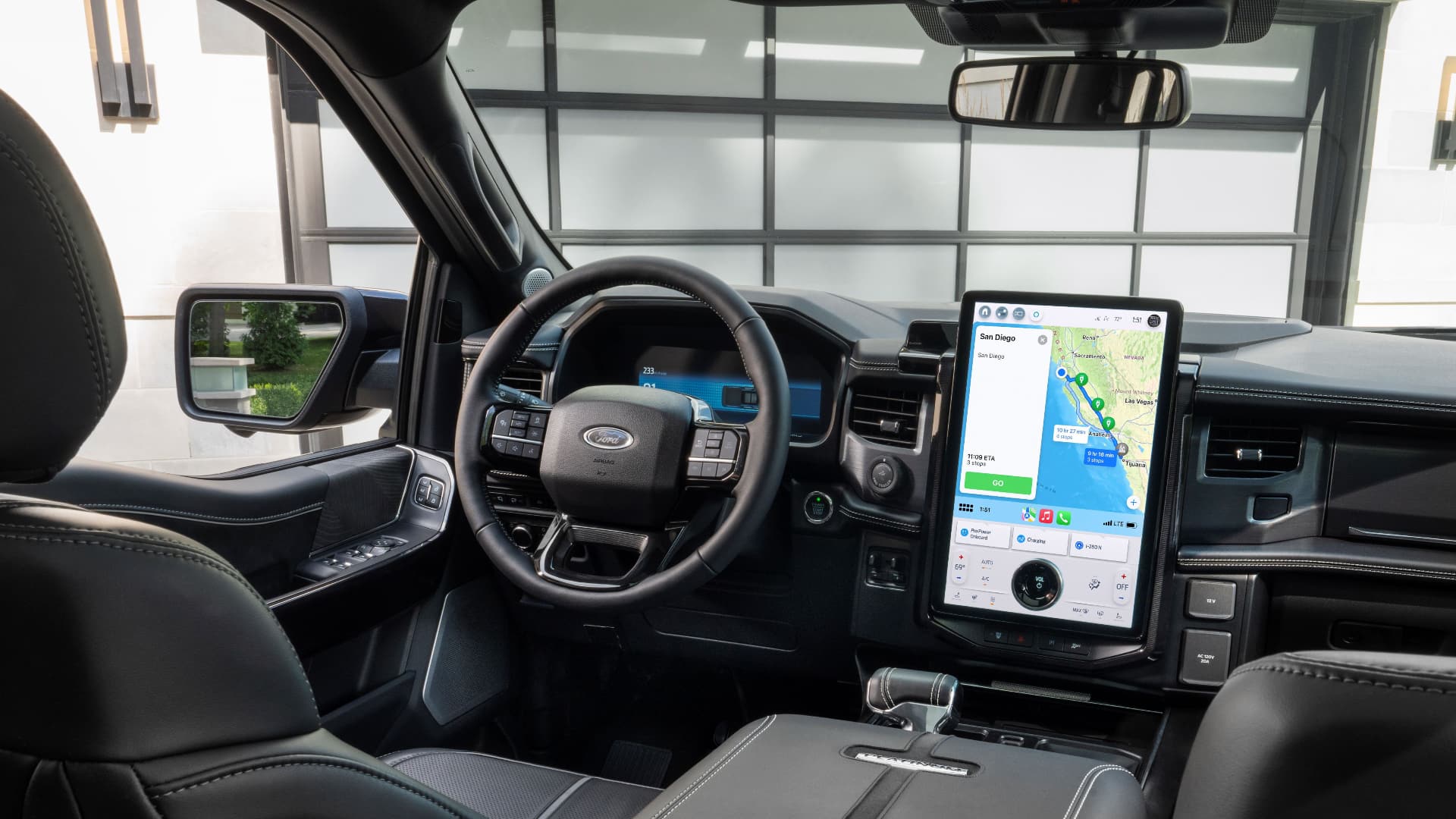 The interior of Ford's F-150 Lightning truck with Apple Maps on CarPlay providing EV routing