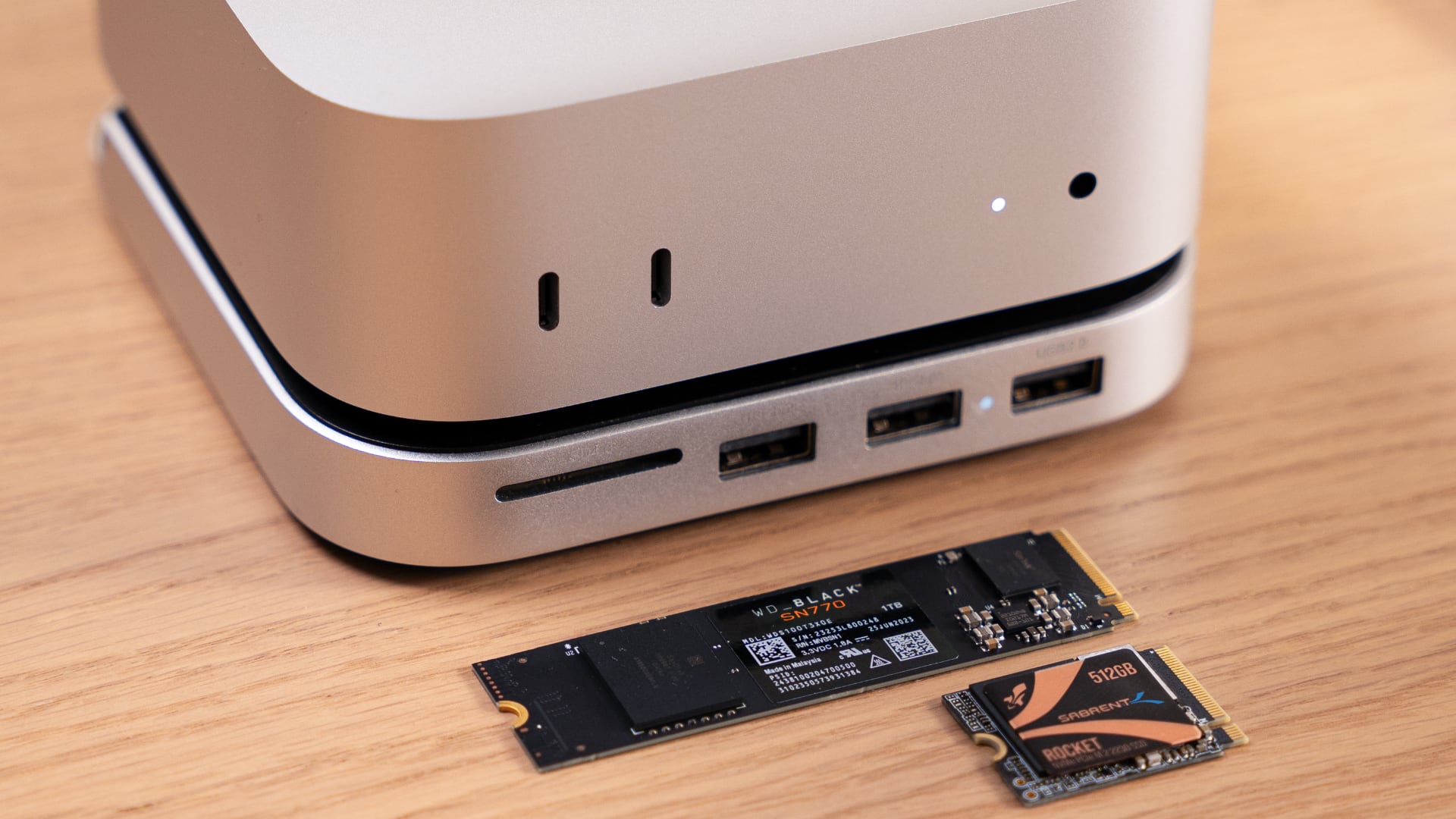 Mac mini on Satechi's hub, with an NVMe card and an SSD chip next to it. 