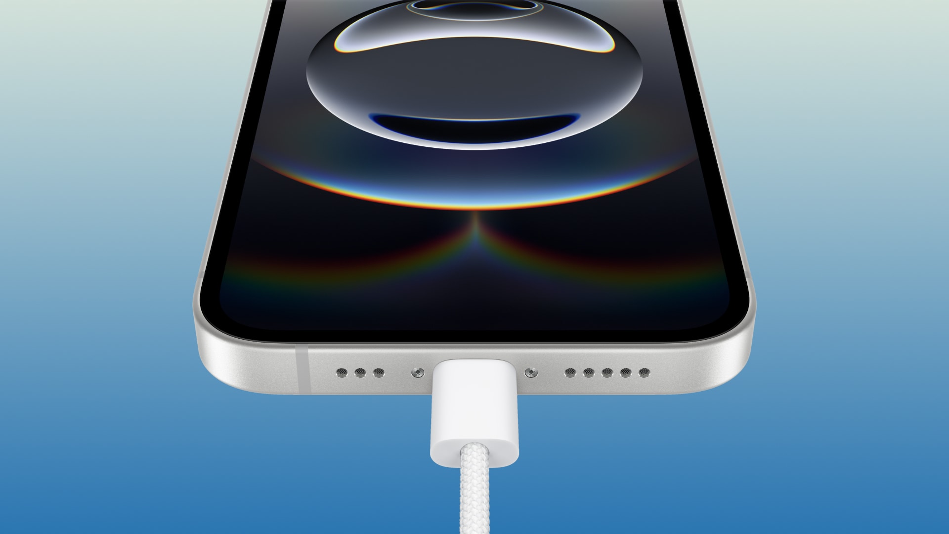 Closeup of the bottom of an iPhone 16e with a charging cable plugged into the USB-C port.