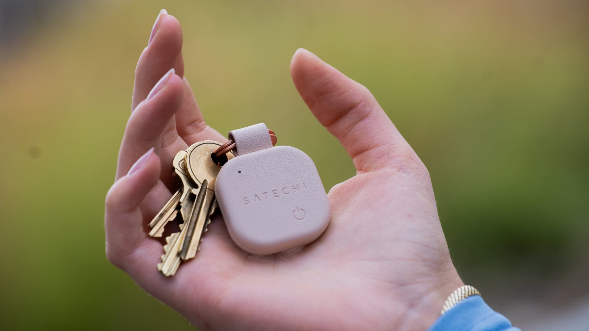 Male hand holding keys on Satechi's tracking keychain.
