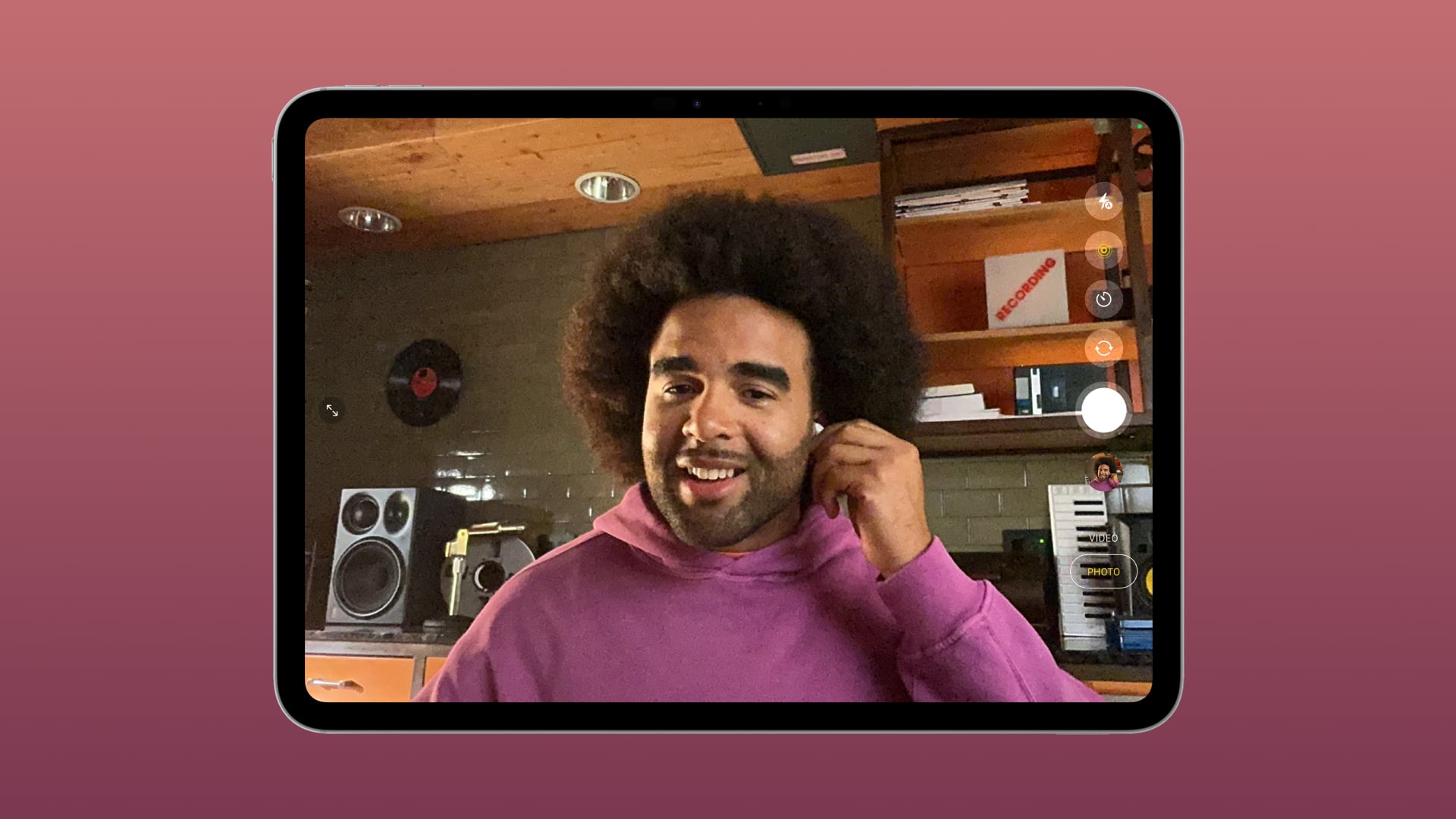 iPad showing a musician on a FaceTime video call wearing AirPods and recording audio. 